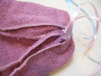 use a washcloth and some ribbon to make a baby bonet shower favor